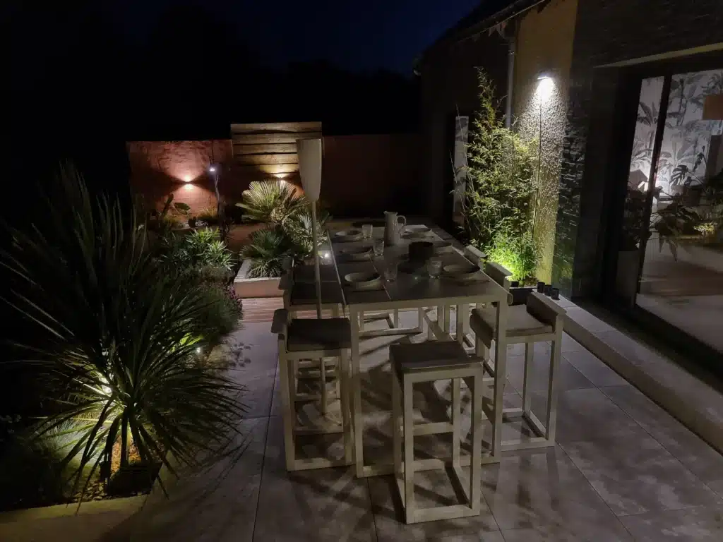 Terrasse avec éclairage filaire architectural et paysager mais manquant d'éclairage convivial au centre de la table